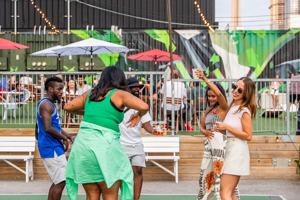 Stackt Market Toronto | Crowd enjoying an event at Stackt Market with warm ambient lighting and live music | Homes Almanac