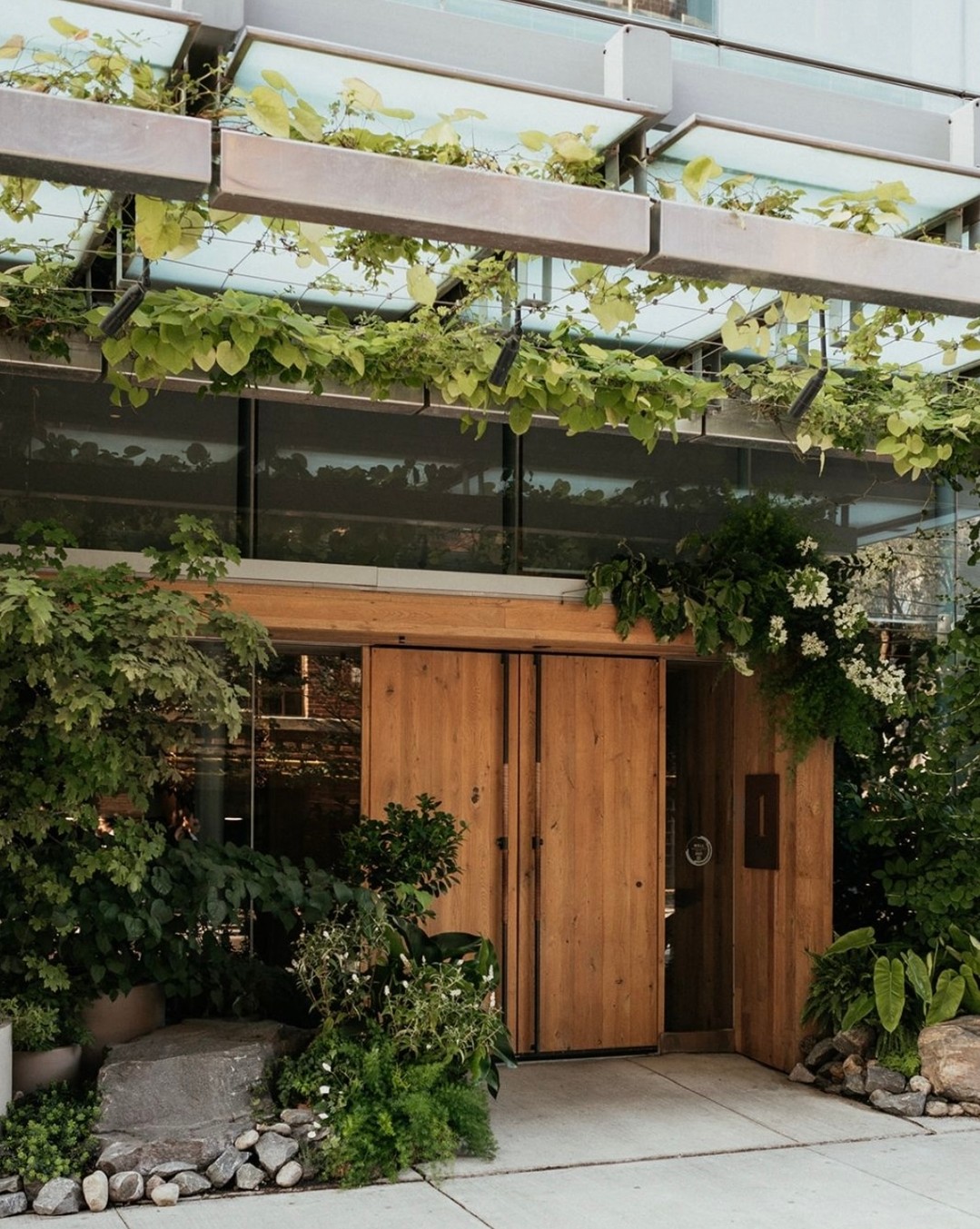 1 Hotel Toronto | Hotel entrance surrounded by greenery and closed oak doors | Homes Almanac