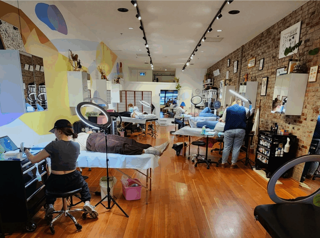 Bebop Ink Vancouver | Interior of a tattoo parlour with brick wall on the right and a colourful mural on the left | Homes Almanac