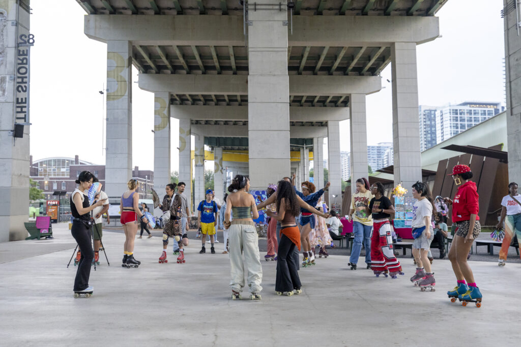 Beneath the Gardiner at The Bentway | Roller skate party with people in brightly coloured clothing on roller skates | Homes Almanac
