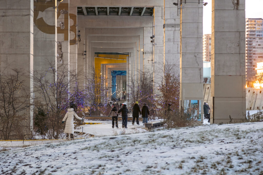 Beneath the Gardiner at The Bentway | Families skate along The Bentway's winding ice rink during the day | Homes Almanac