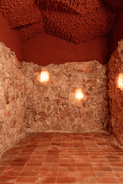 trove wellbeing | Softly lit salt room with floor to ceiling pink salt rocks and tiled floor | homes almanac