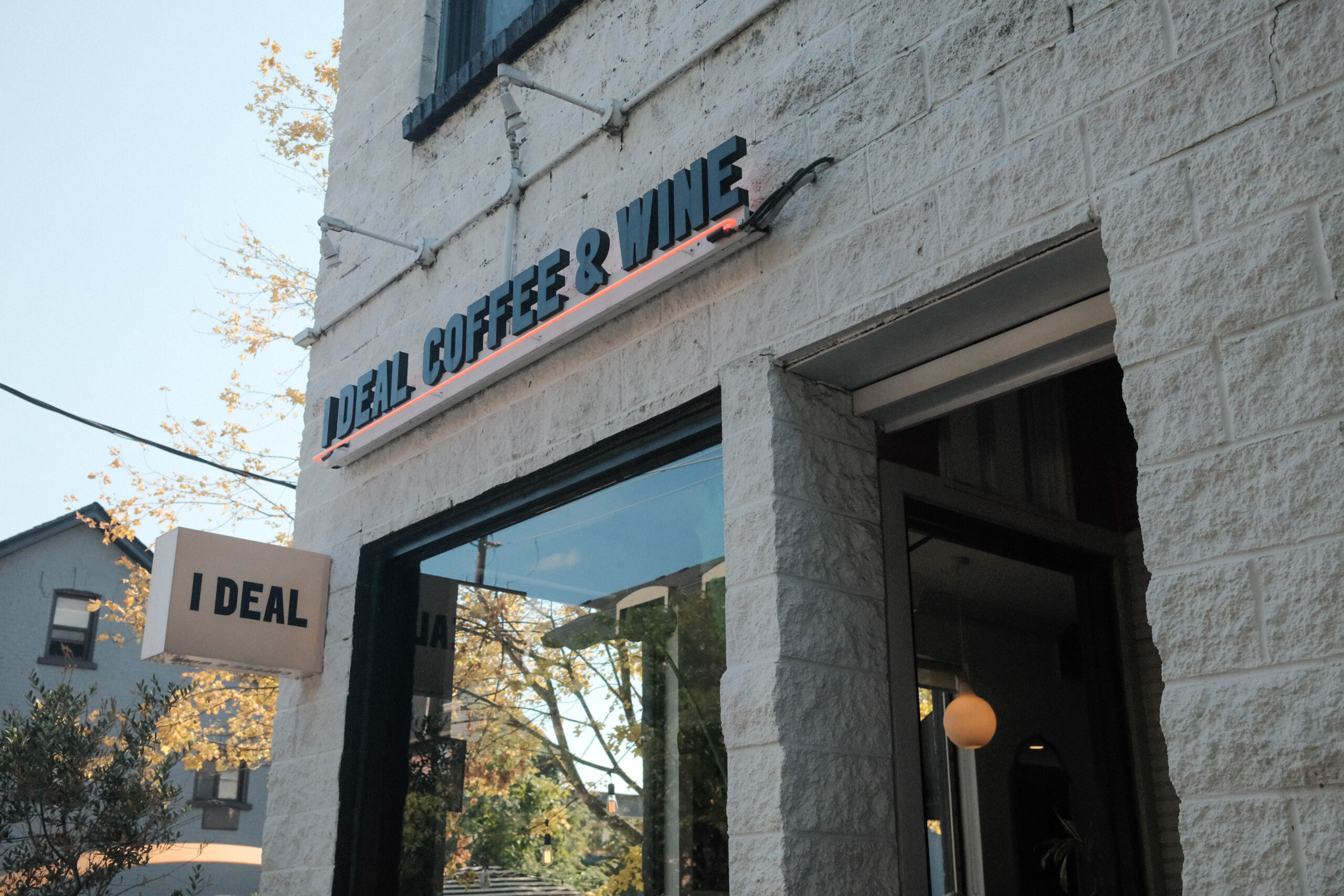 i deal coffee & wine on ossington | Exterior of coffee shop with white brick facade | Homes Almanac