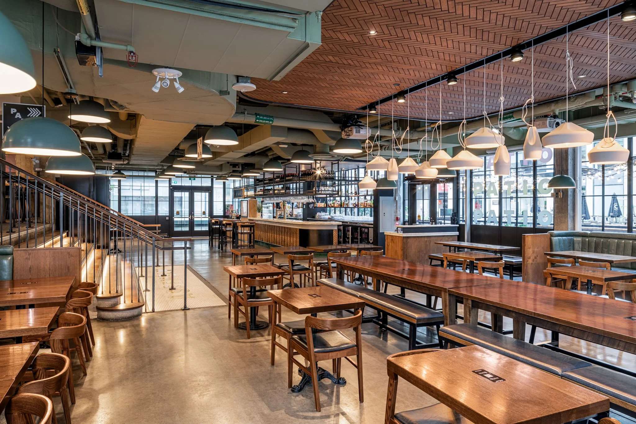 Chefs Hall | Brightly lit restaurant with wood tables and chairs and floor to ceiling windows | Homes Almanac