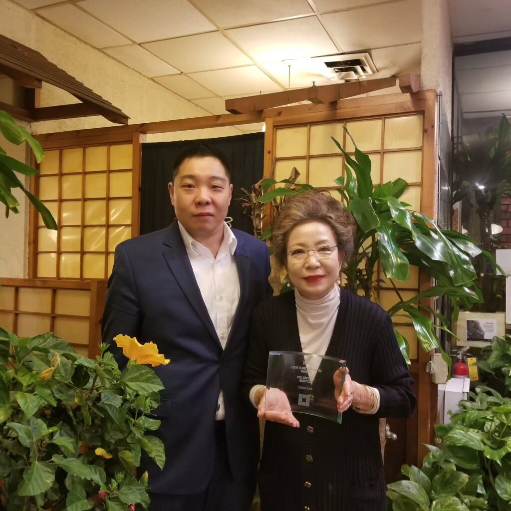 Jason and his late mother Ok Re Lee holding an award in their restaurant | Korean Village in Koreatown | Homes Almanac