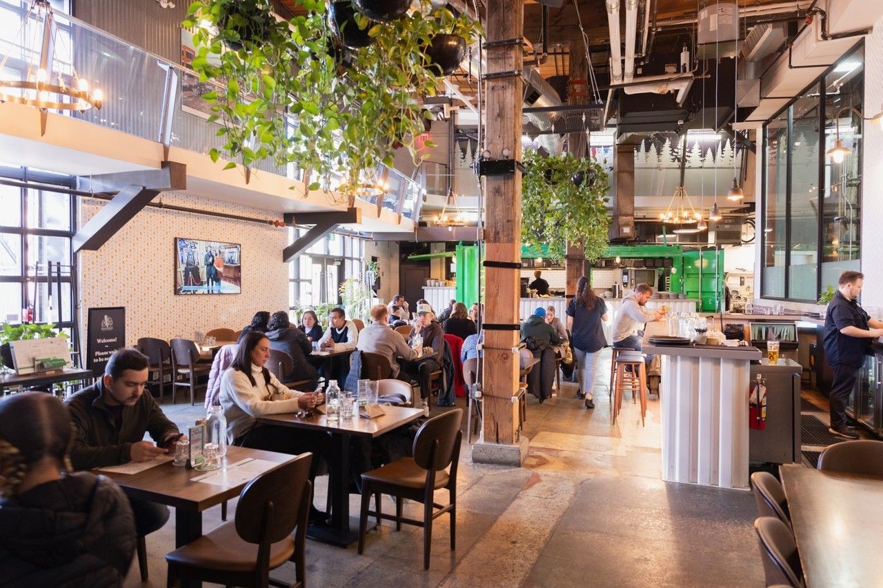 Steamwhistle Brewing | Bright interior with people sitting at tables | Homes Almanac