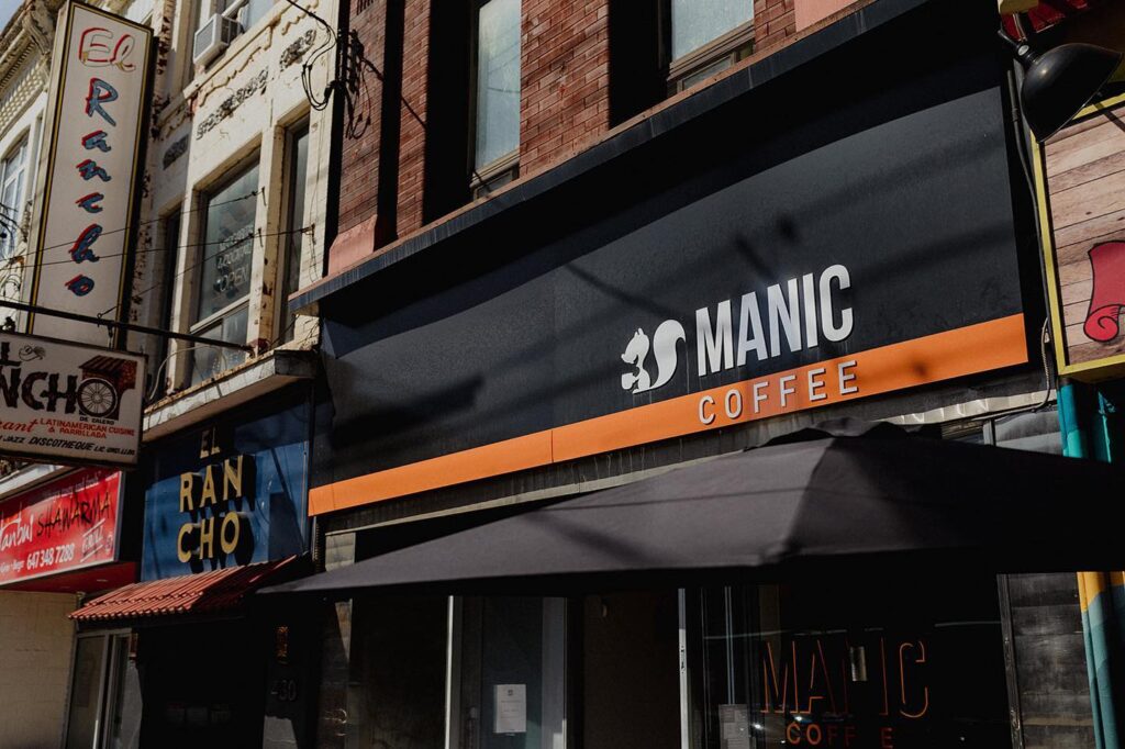 Manic Coffee | A black awning with white and orange logo | Homes Almanac