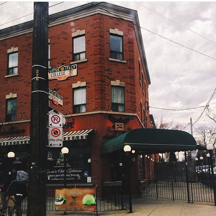 Sicilian Sidewalk Cafe | 2 storey brick building on a grey day with a green entryway awning | Homes Almanac