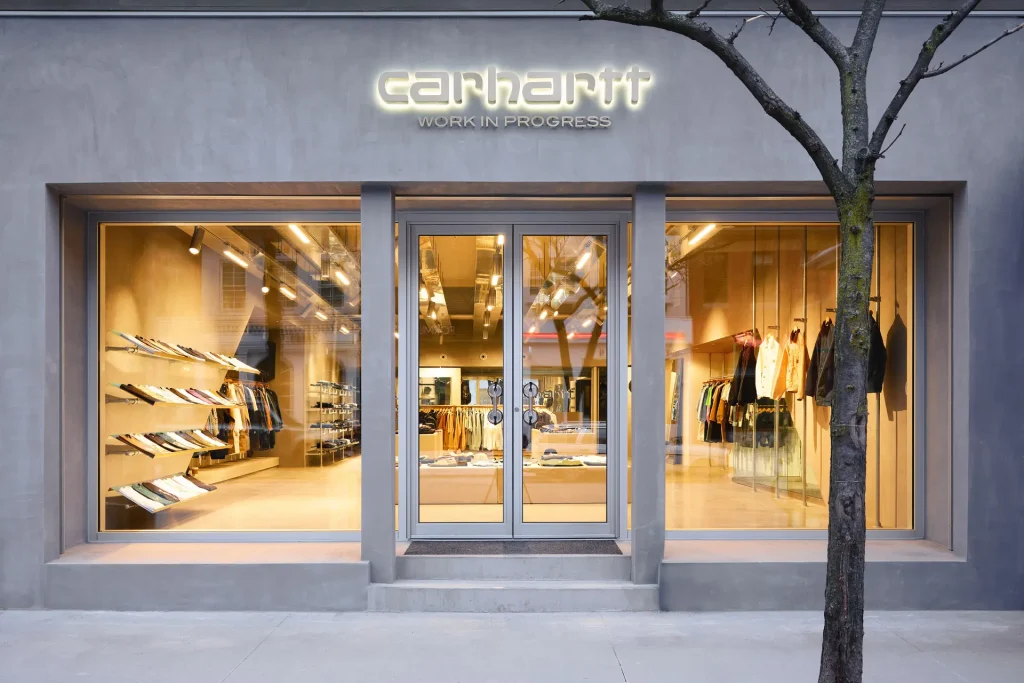 Carhartt WIP - Grey exterior with floor to ceiling windows looking into a brightly lit store with clean rows of clothing | Homes Almanac