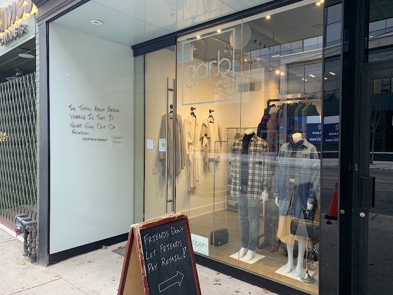 Garb Consignment | Floor to ceiling window with mannequins dressed in denim and a sandwich board sitting on the sidewalk | Homes Almanac