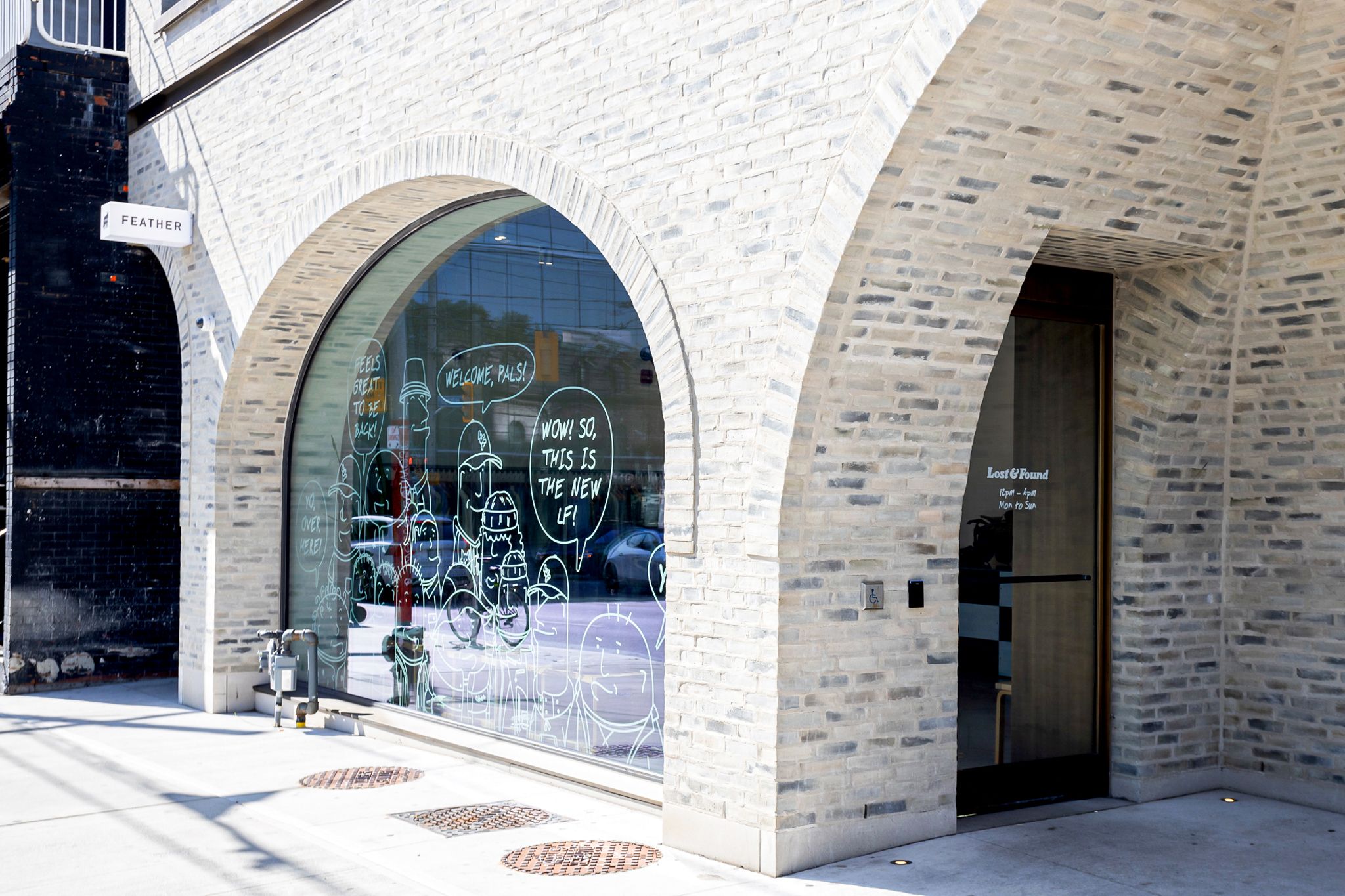 Lost & Found | Sunny day white brick facade with arched floor to ceiling windows and arched entryway | Homes Almanac