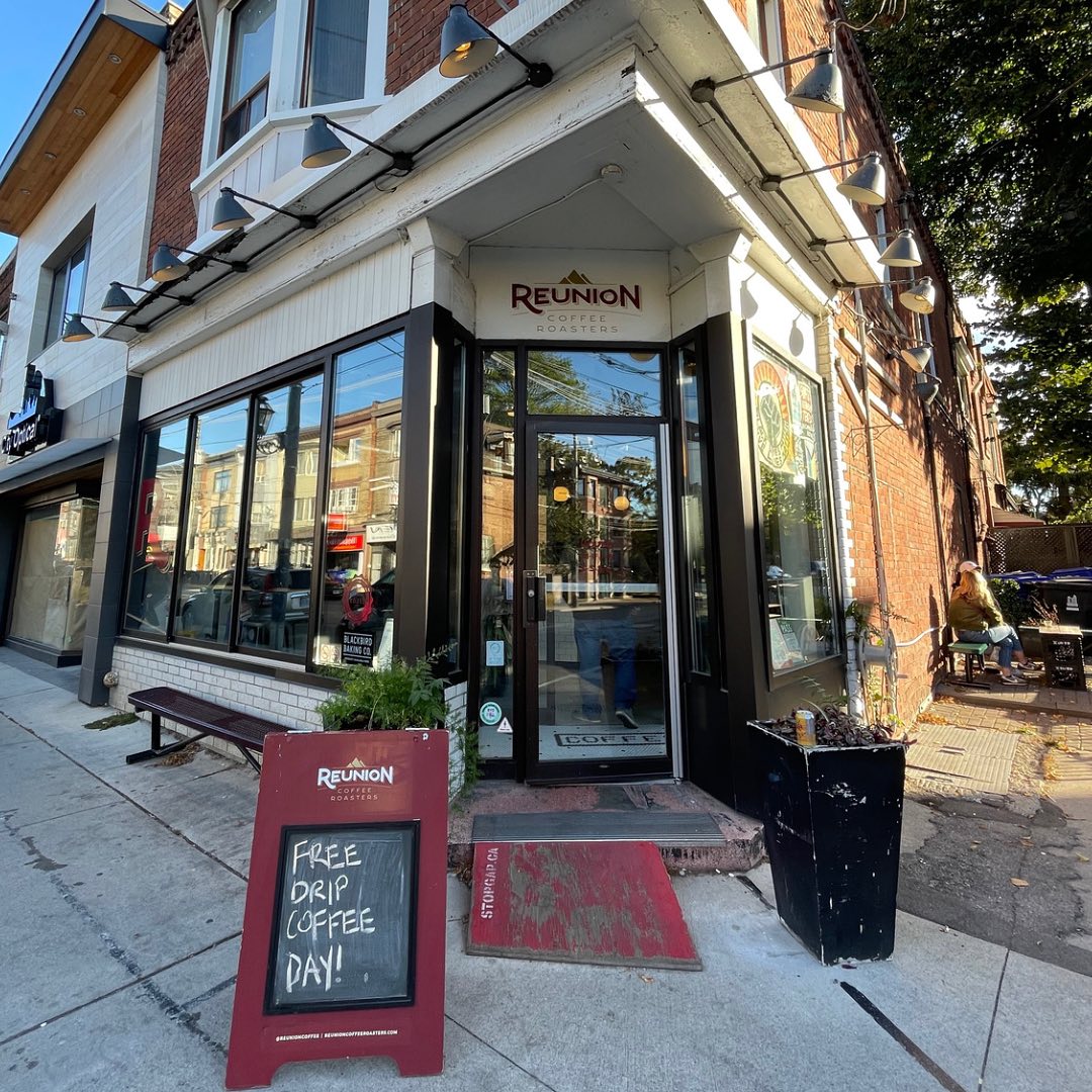 Reunion Coffee Roasters | White brick and tile exterior with "Reunion" written in burgundy over the door and a sandwich board to the left | Homes Almanac