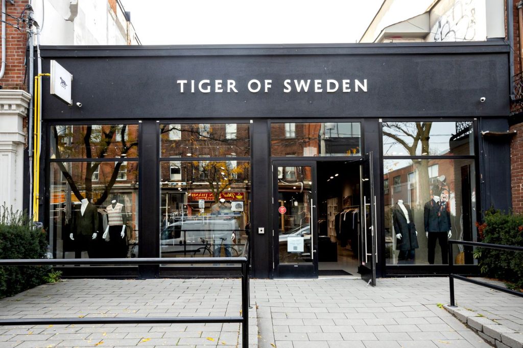 Tiger of Sweden | Minimalist black exterior with logo in white and full length floor to ceiling windows cover the entire front facade | Homes Almanac